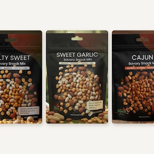 May include: Three black snack pouches labeled Salty Sweet, Sweet Garlic, and Cajun Savory Snack Mix. Each bag features a graphic of peanuts, almonds, and toasted corn, with the Spice Project logo and text instructions printed on the front.