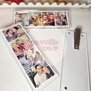 May include: Clear acrylic photo bookmarks with multiple family photos. One bookmark has a series of photos, and the other has a single row of photos. The text "avella co.&hearts;" is visible on the surface.