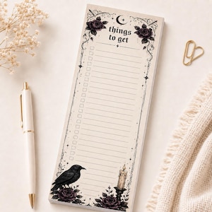 May include: A rectangular notepad with a cream background featuring the text things to get at the top. The border is decorated with black roses, a crescent moon, stars, a raven, and a lit candle. It includes a vertical list of checkboxes.