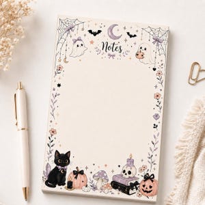 May include: A rectangular notepad with a cream background and a decorative border featuring the word Notes, ghosts, bats, a crescent moon, spiderwebs, bows, flowers, a black cat, pumpkins, a skull on books, and mushrooms in pastel colours.