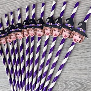 May include: Purple and white striped paper straws with witch hat toppers featuring a woman's face.