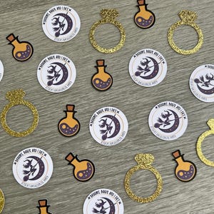 May include: An assortment of party decorations, including gold glitter ring cutouts, potion-shaped stickers, and round stickers with a witch on a broom and the text "Brooms, Booze, and I Do's".