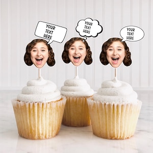 May include: Three cupcakes with white frosting topped with personalized cupcake toppers featuring a photo of a person's face and a speech bubble that says "Your Text Here".