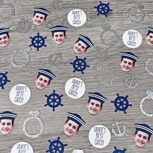May include: A collection of confetti featuring a nautical theme. The confetti includes anchors, steering wheels, rings, and images of people wearing sailor hats. The confetti is printed with the text "Laurie's Best Catch".