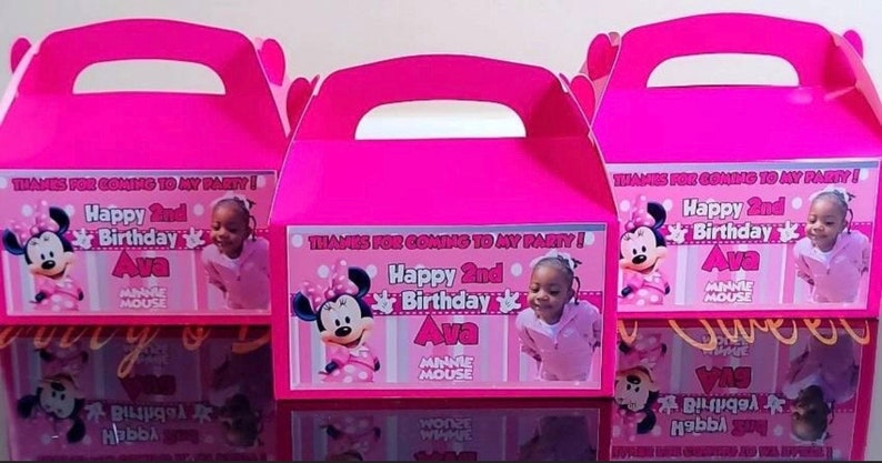 May include: Pink favour boxes featuring Minnie Mouse and a girl's photograph. The boxes are decorated with the text "Thanks for coming to my party! Happy 2nd Birthday Ava Minnie Mouse".