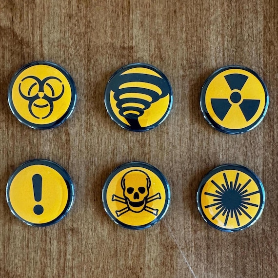 Hazard Symbol Button Magnet Pack. 6-pack of 1.5” round metal refrigerator magnets.