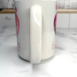 May include: White ceramic mug with a pink heart and the text "For Coffee & Cuddles" on it.