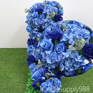 以下が含まれることがあります： 青いバラとアジサイを組み合わせた垂直方向の花の配置。さまざまな青の色合いで、緑の葉がアクセントになっています。「craftssupply988」の文字が下部に表示されています。花のクローズアップ。