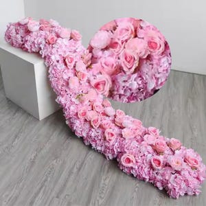 May include: A long garland of pink artificial flowers, featuring a mix of roses and hydrangeas. The garland is perfect for adding a touch of elegance to any event.