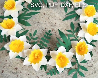 Può includere: Una ghirlanda artigianale di carta con narcisi di carta bianca e gialla e foglie di carta verde. La ghirlanda è decorata con il testo "SVG, PDF, DXF, EPS".