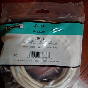 May include: A white 6-foot CAT 5e 8-conductor tangle-free RJ45 plug-to-plug patch cord in a clear plastic bag. The label reads "UTPCH6 POWERSUM CAT 5e 8 CONDUCTOR TANGLE-FREE RJ45 PLUG-TO-PLUG PATCH CORD LENGTH: 6 FEET (1.8m) COLOR: WHITE 1 PC 0 74983 70868 0 60304927U - 2 (16985) MADE IN COSTA RICA".