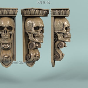 May include: Three ornate, decorative wall brackets with a skull design. Each bracket features a detailed skull with a carved, swirling design. The brackets are made of a light brown material and have a vintage aesthetic.