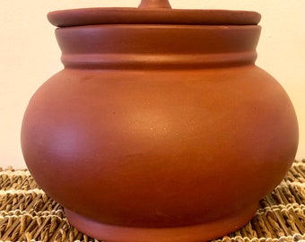 大きな陶器の土鍋。蓋と 2 つの取っ手が付いた土鍋。素朴な田舎
