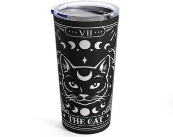 May include: Black and white stainless steel tumbler with a tarot card design featuring a cat with a crescent moon on its forehead. The card reads "The Cat" and "VII" in a decorative font.