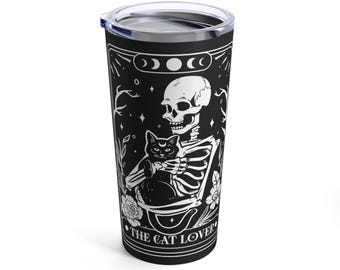 May include: Black and white illustration of a skeleton holding a black cat. The image is on a black stainless steel tumbler with the text "The Cat Lover".
