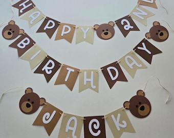 May include: A brown and tan banner with white letters that reads "Happy 2nd Birthday Jack". The banner is decorated with brown bear faces.