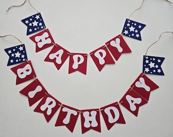 May include: A two-tiered banner spelling out HAPPY BIRTHDAY in white letters on red swallowtail flags. The banner includes four dark blue swallowtail flags featuring white stars, all strung together on thin brown twine for hanging.