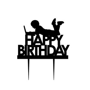 May include: Black silhouette of a person using a laptop with the words "Happy Birthday" below. The silhouette is on a cake topper.