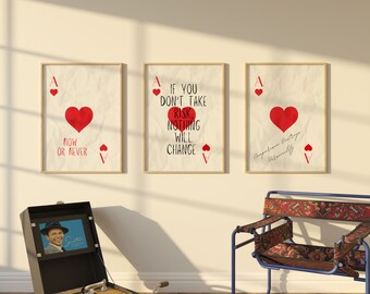 May include: Three framed prints with a red heart and text on a beige background. The text on the prints reads "Now or Never", "If you don't take risk nothing will change", and "Comparison Draftogo Fermality".