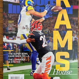 May include: Sports Illustrated magazine cover featuring a photo of two football players in action. The cover text reads "RAMS House" and "The Super Bowl came back to L.A. The Lombardi is staying."