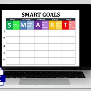 May include: A laptop screen displaying a SMART goals worksheet with a table labeled with the acronym SMART, which stands for Specific, Measurable, Attainable, Realistic, and Timely. The table has five rows and six columns. The first column is numbered 1 through 5. The second column is labeled "Specific" and has a green background with the letter "S". The third column is labeled "Measurable" and has a blue background with the letter "M". The fourth column is labeled "Attainable" and has a purple background with the letter "A". The fifth column is labeled "Realistic" and has a yellow background with the letter "R". The sixth column is labeled "Timely" and has a red background with the letter "T".