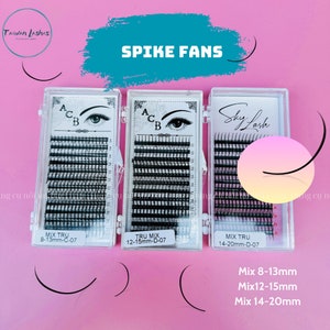 May include: Three clear plastic boxes containing black eyelash extensions. The boxes are labeled "Mix Tru 8-13mm-C-07", "Tru Mix 12-15mm-D-07", and "Mix Tru 14-20mm-D-07". The boxes are on a pink background. The text "Spike Fans" is written in black on a blue background above the boxes.
