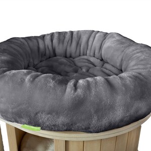 K&ouml;nnte beinhalten: Ein graues, pl&uuml;schiges Katzenbett mit runder Form, das auf einem Katzenbaum aus Holz steht. Das Bett hat ein weiches, einladendes Aussehen, perfekt f&uuml;r den Komfort der Katze. Der Katzenbaum hat eine nat&uuml;rliche Holzoberfl&auml;che.
