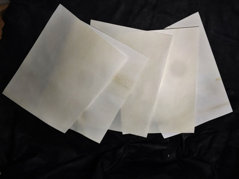 May include: Five white sheets of paper stacked on top of each other. The paper is slightly textured and has a subtle sheen.