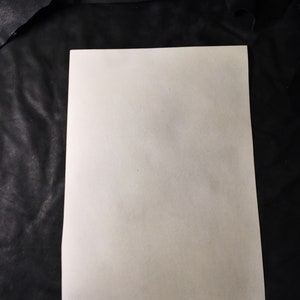 May include: A blank white sheet of paper on a black background.
