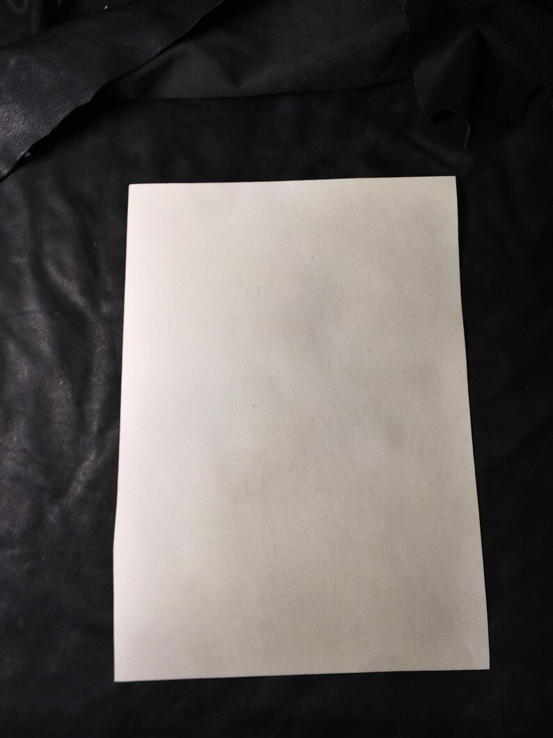 May include: A blank white sheet of paper on a black background.