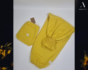 May include: A mustard yellow pair of pants with an elastic waistband and a drawstring. The pants are made of a soft, lightweight fabric and are perfect for lounging or working out. The pants come with a matching mustard yellow drawstring bag.