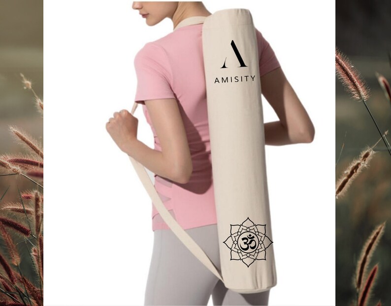 May include: A white yoga mat carrier with a black "A" logo and the word "AMISITY" printed on it. The carrier has a black Om symbol inside a flower design on the bottom.