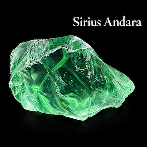 May include: A translucent, vibrant green Sirius Andara crystal with a jagged, irregular shape and a glass-like texture. The surface features sharp, angular facets and smooth, curved ridges that catch the light, set against a solid black background.
