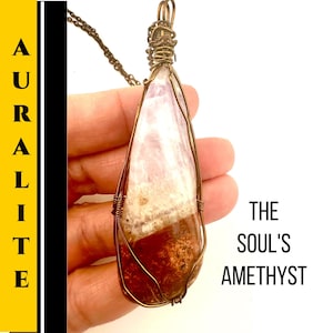Może przedstawiać: Wisiorek Auraleite w kształcie łzy z miedzianym drutem. Kamień ma mieszankę kolorów, w tym biały, różowy i ciemnobrązowy. Tekst "The Soul's Amethyst" jest wyświetlany po prawej stronie obrazu.