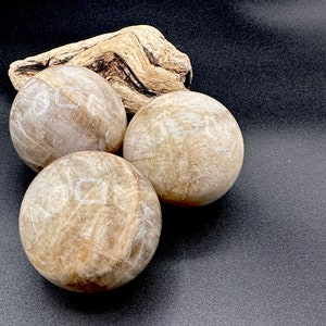 Natural Moonstone Crystal Ball 55-60mm with beautiful shimmer and polished finish. Decorative crystal sphere for home decor, meditation space, sacred altar, spiritual room, office display, crystal collection, birthday gift, Christmas gift, gift for her, gift for witch, gift for crystal lover, and unique gemstone sphere for collectors seeking meaningful and beautiful natural crystal decor.