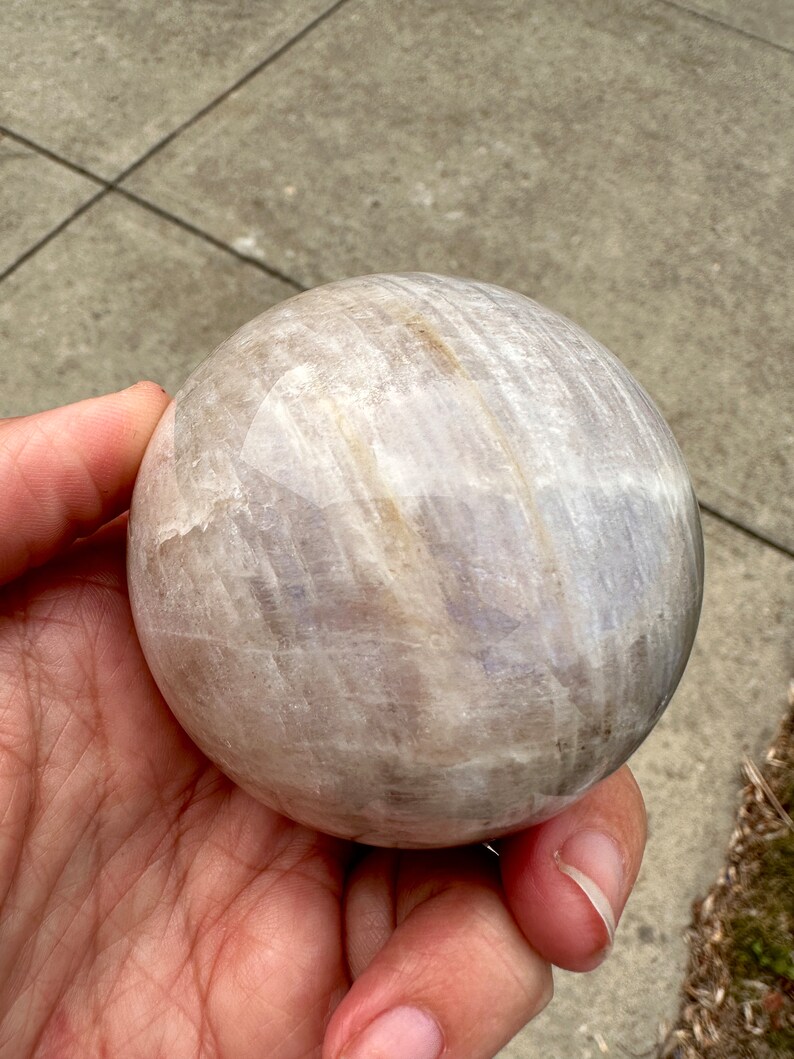 Moonstone Crystal Ball natural moonstone sphere 55-60mm chosen by a Sami Shaman and encoded to Freya. Crystal ball for Reiki practitioners, meditation, yoga, energy healing, intuition development, psychic abilities, spiritual awakening, moon rituals, and chakra balancing. Moonstone sphere associated with inner wisdom, emotional balance, feminine energy, self-discovery, and deeper spiritual connection.