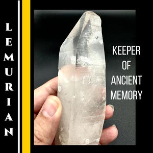 May include: A clear quartz crystal with a pointed tip, held against a black background. The text "KEEPER OF ANCIENT MEMORY" is displayed in white. The word "LEMURIAN" is written vertically in white.