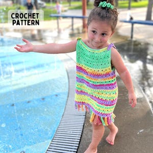 Può includere: Un abito all'uncinetto senza maniche con righe orizzontali verde neon, giallo, rosa e viola e un orlo sfrangiato. Il capo presenta uno scollo quadrato e laccetti sulle spalle. Il testo CROCHET PATTERN è visibile nell'angolo in alto a sinistra.