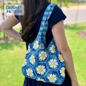 Könnte beinhalten: Eine blaue Häkeltasche mit einem Gänseblümchenmuster. Die Tasche hat weiße und gelbe Blumenmuster in blauen sechseckigen Formen. Der Träger und der Körper der Tasche sind aus einem blau-weiß gestreiften Muster gefertigt. Der Text "CROCHET PATTERN" befindet sich oben links.