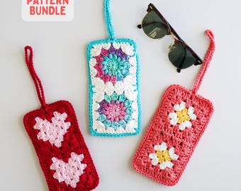 May include: Three rectangular crochet tags with hanging loops. One is red with pink hearts, one is turquoise with multicolored floral motifs, and one is coral with white and yellow flowers. A pair of tortoiseshell sunglasses is included.