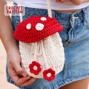 May include: A crochet mushroom-shaped bag with a red cap and white spots. The bag has a cream-colored body with red flower accents and a cream-colored strap. The words "CROCHET PATTERN" are in the upper left corner.