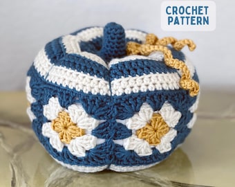 May include: A crocheted pumpkin featuring a blue and white striped top and a middle section composed of blue, white, and mustard yellow granny square flower motifs. The pumpkin has a small blue stem and curly mustard yellow yarn tendrils. Text reads CROCHET PATTERN.