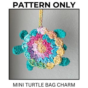 May include: A crochet mini turtle bag charm with a multicolored shell featuring pink, purple, yellow, and blue yarn. The turtle has a solid teal head and four teal flippers. A yellow and orange braided cord is attached to the top. Text reads PATTERN ONLY MINI TURTLE BAG CHARM.
