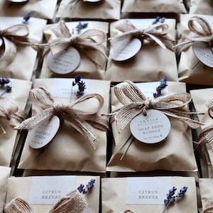 May include: A collection of small brown paper bags tied with twine and decorated with lavender sprigs. Each bag contains a soap ends bundle and has a round label that reads "Choice Natural Soap - Soap Ends Bundle - Net Wt 280g". Some bags also have a small label with the scent name, such as "Citrus Breeze" or "Orange Clove".