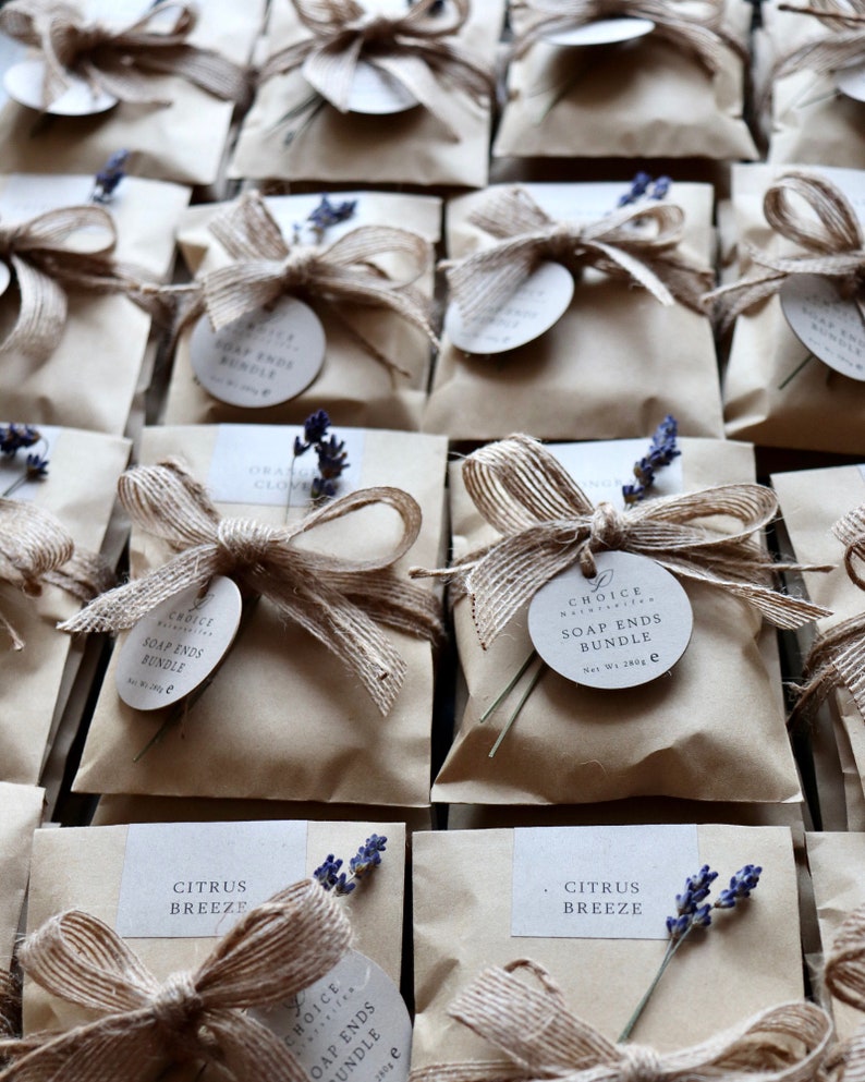 May include: A collection of small brown paper bags tied with twine and decorated with lavender sprigs. Each bag contains a soap ends bundle and has a round label that reads "Choice Natural Soap - Soap Ends Bundle - Net Wt 280g". Some bags also have a small label with the scent name, such as "Citrus Breeze" or "Orange Clove".