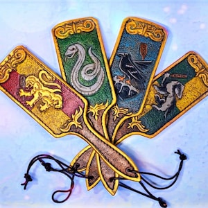 Può includere: Quattro portachiavi in ​​pelle con diversi stemmi di casa della serie Harry Potter. Ogni portachiavi presenta uno stemma diverso con un leone, un serpente, un corvo e un tasso.