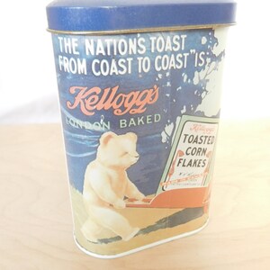 May include: A blue and white tin container with a cartoon bear and the text "The Nation's Toast From Coast to Coast Is Kellogg's London Baked Toasted Corn Flakes".