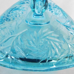 May include: A light blue glass candy dish with a swirl pattern. The dish has a lid with a knob on top.