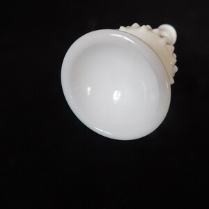 May include: White milk glass vase with a textured, knobby design. The vase has a wide, round base and a narrow neck.