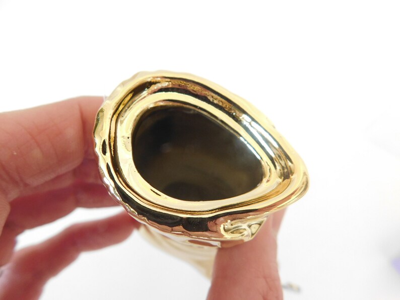Puede incluir: Jarr&oacute;n de cer&aacute;mica de color dorado con un exterior texturizado y una abertura redonda y lisa. El jarr&oacute;n est&aacute; vac&iacute;o.
